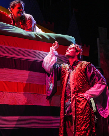 Prince Dauntless (Mike Culhane) holds the tiny pea that was buried under all the mattresses of Princess Winnifred’s (Meg Nemeth) bed. Photo by Andrew Culhane.